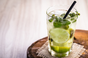 mojito, Cuban drink known worldwide. Fresh Mojito in glasses on wooden table.