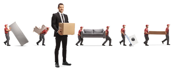 Man in a suit with a cardboard box and workers from a moving company carrying home appliences and...