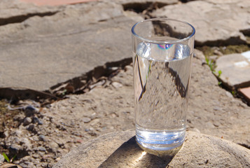 The water in the glass on the stone slabs.