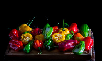 Colorful chili peppers on a black background, this species is sweet in taste, very common in South America.