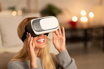 Excited Girl Using VR Headset Playing Videogame At Home