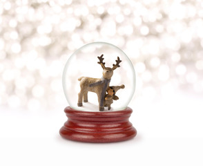 Fototapeta na wymiar Christmas snow globe on white. Can be used as a Christmas or a New Year gift or symbol. Christmas and New Year design element. Toy glass snow globe with deer and baby. Snow ball on white.