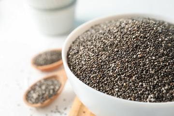 Bowl and spoons with chia on white background, close up