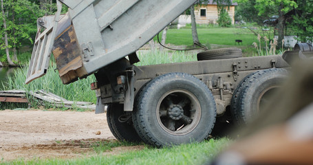 Close-up of a truck going along the shore of a lake. Construction.