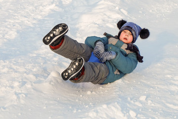 Child rides on an ice-boat from a snow slide. Sledding snow saucer.