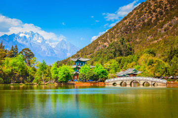 Heilongtan Pool (Black Dragon Pool) with marble bridge and Jade dragon mountain at Old Town of Lijiang in Yunnan China