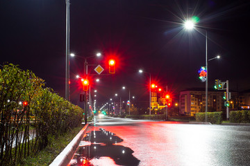 a deserted night road illuminated by led lights after rain in a provincial town