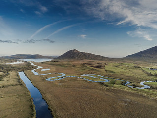 Beautiful view in Connemara, Mountains rivers flow into lake, Blue cloudy sky, Aerial view.