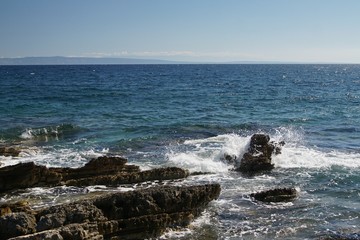 Fototapeta na wymiar Felsenküste in der Adria mit Blick aufs Meer und brechenden Wellen