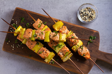 Grilled salmon skewers. Salmon fish with leeks on skewers. View from above, top studio shot