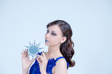 Young woman in creative image with silver artistic make-up.Winter, Christmas Girl Make up. Holiday Make-up with gems. Snow Queen High Fashion Portrait. Eyeshadows, False Eyelashes and Crystals