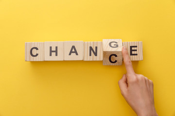 cropped view of woman switching wooden cube from word change to chance on yellow background - obrazy, fototapety, plakaty