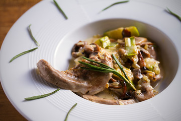 Veal tongues with stewed vegetables and cream sauce, garnished with rosemary