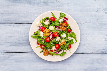 Fresh salad with arugula, radicchio, tomato cherry, baby mozzarella, walnuts