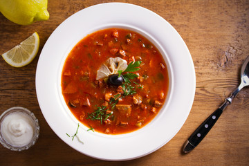 Solyanka - thick, spicy and sour Russian soup, made of beef, ham, sausages, chicken breast cucumber pickles and tomatoes