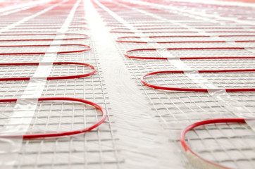 Electric underfloor heating red mats on cement floor. Copy space background. Renovation and...