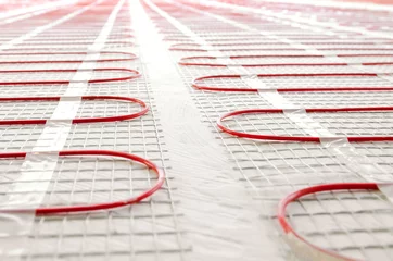 Electric underfloor heating red mats on cement floor. Copy space background. Renovation and construction, comfortable warm home concept. © Anna Ria