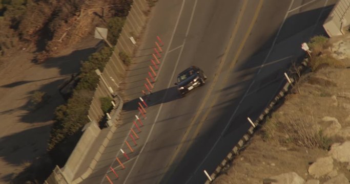 Helicopter shot of cars on California PCH highway angled upside down, day