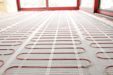 Electric underfloor heating red mats on cement floor. Heating red electrical cable on cement floor...