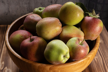 Green and red fresh apples in a wooden bowl. Autumn harvest set