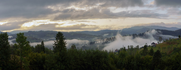 Panoramic view of foggy valley between carpathian mountains at morning
