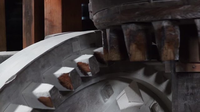 Close up of mill stones processing grain inside a windmill at zaanse schans near amsterdam, netherland. Slow motion
