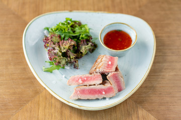 Medium rare tuna with lettuce and hot sauce. Restaurant menu