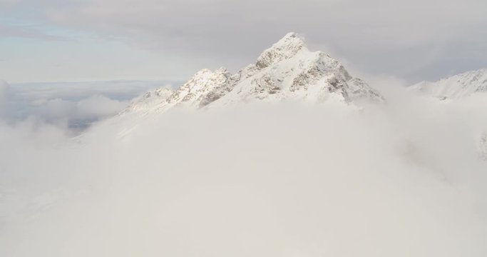 Aerial helicopter shot, fly over mountain peak and approach second one, drone footage