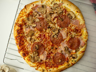 Pizza zrobiona w domu, salami, ser, pieczarki. Widok z góry.