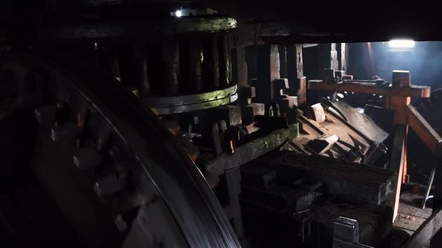 Close up gears of mill stones processing grain inside a windmill at zaanse schans near amsterdam, netherland. Slow motion