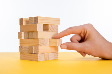 cropped view of woman tacking piece of wooden building on yellow surface isolated on white