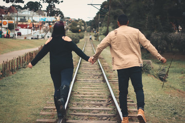 casal andando na linha do trem