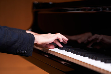 Fototapeta premium Closeup man's hand playing piano. Music performer's hand