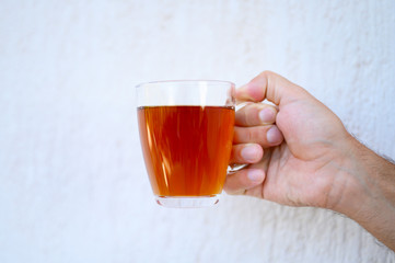 glass cup of tea in the male hand