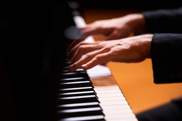 Obraz premium Closeup man's hand playing piano. Music performer's hand