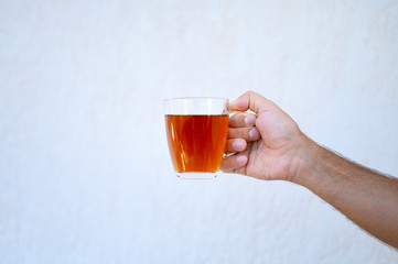 glass cup of tea in the male hand