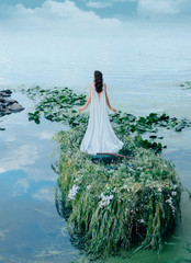Fototapety  Tajemnicza kobieta w długiej białej sukni płynie łodzią na spotkanie błękitnego nieba i chmur. Wystrój z trawą, gałęziami i kwiatami. Niezwykły kreatywny ślub. Strzelanie z tyłu bez twarzy