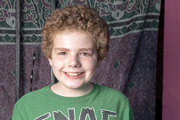 Smiling young boy in front of purple backdrop
