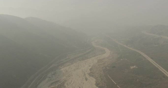 Aerial shot, day, hazy high altitude view of river deposit, drone