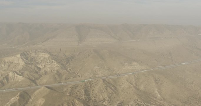 Aerial shot, day, hazy view of desert highway, drone