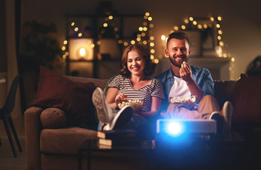 Family couple watching television at home on sofa