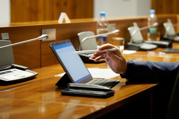 A man, official, businessman or deputy uses the touch screen of a tablet computer