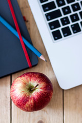 FIRST APPLE PLANE ON WORK TABLE WITH NOTEBOOK AND COMPUTER.
