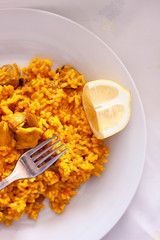 TYPICAL YELLOW RICE PLATE OF SPAIN WITH LEMON ROLLING OVER CLEAR FUND