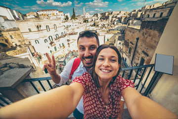 happy tourist travelling in south of italy, posing in a selfie photo in Matera, Basilicata, unesco...