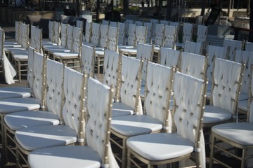 Closeup shot of white chairs for the guests of a wedding ceremony
