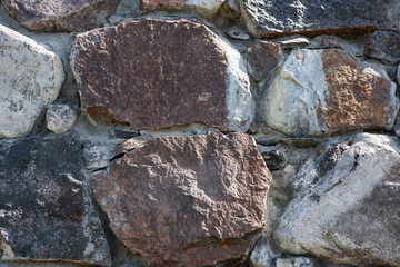 The texture of the uneven stone wall of large cobblestones
