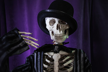 Funny human skeleton in a jacket and bowler hat. Halloween,