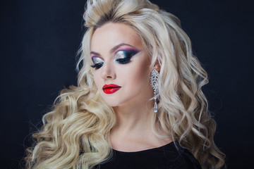 Fototapeta premium Portrait of a young luxurious blonde with long curls.