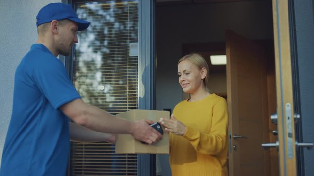 Beautiful Young Woman Opens Doors of Her House and Meets Delivery Man who Gives Her Cardboard Box Postal Package, She Signs Electronic Signature POD Device. Slow Motion